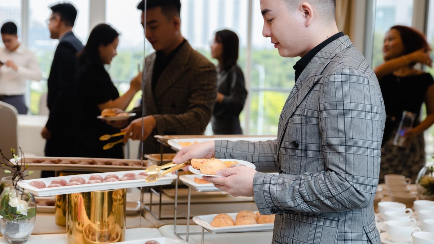 Corporate guests serving themselves at an office event buffet counter