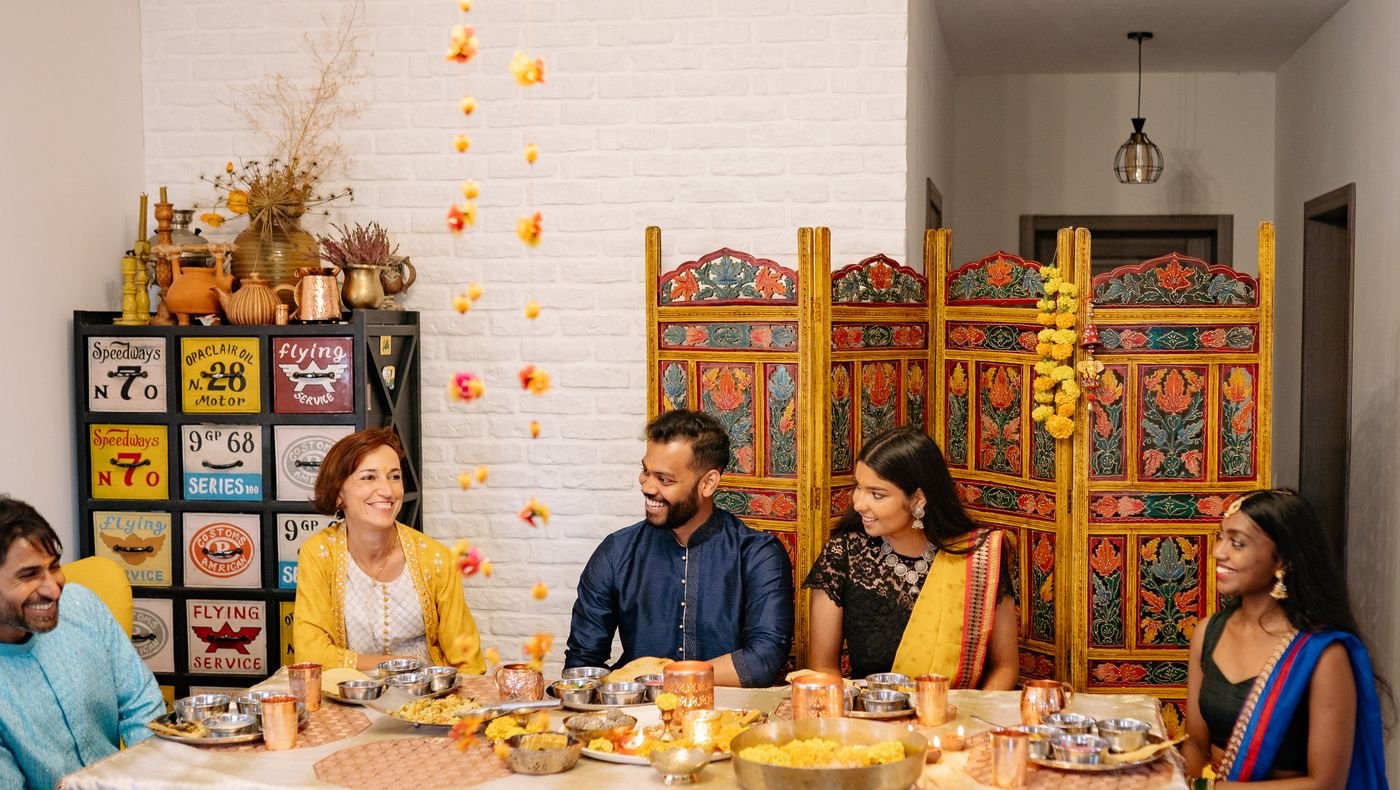Indian family sharing a festive vegetarian thali meal around one dining table